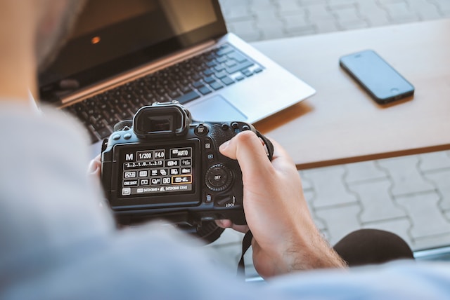 Photographer working on his DSLR camera in café.