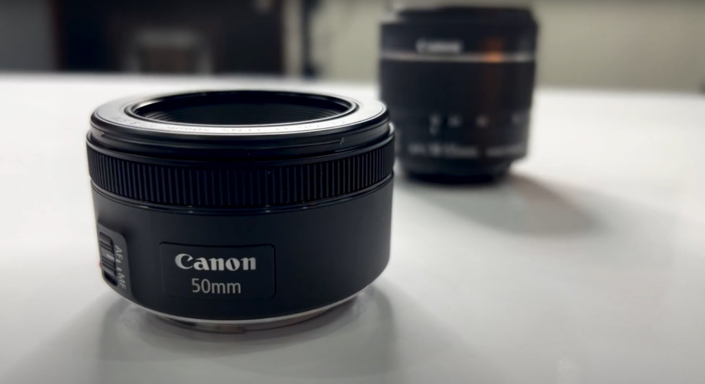 the 50mm Canon camera lens on a white table with a different type of lens in the background