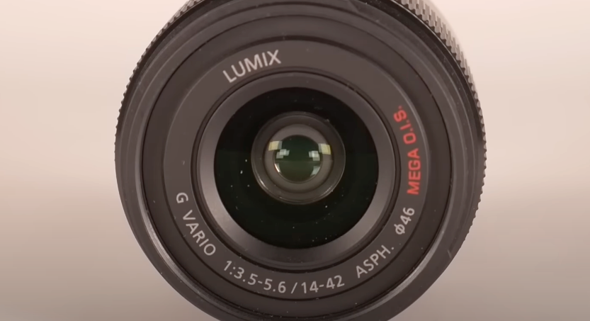 A front view of a black camera lens displaying its lens and text details.