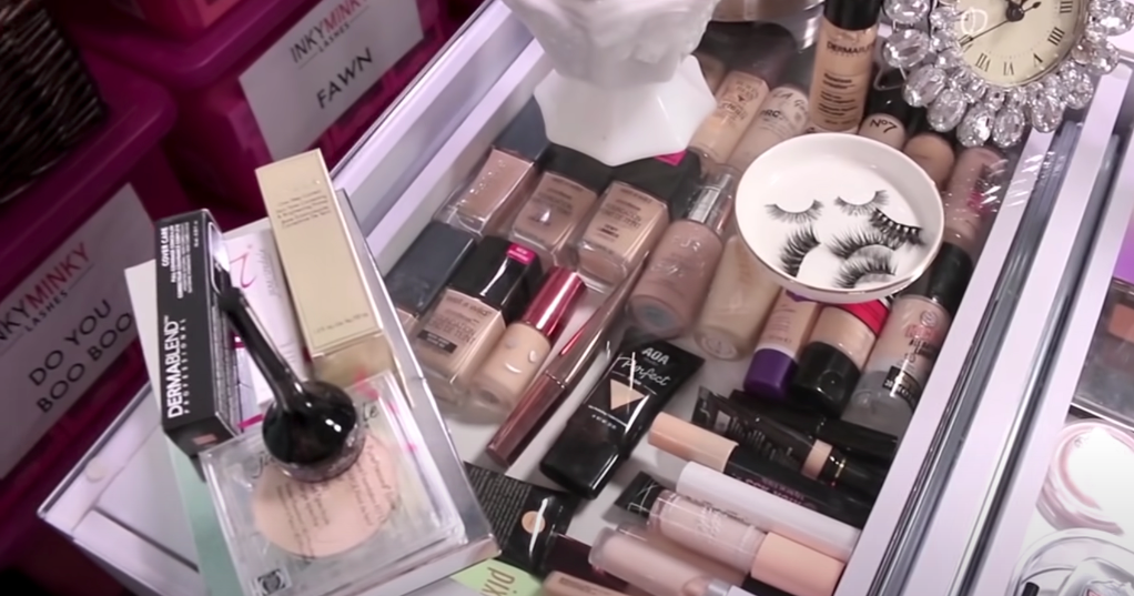 A diverse makeup collection featuring foundations, brushes, false eyelashes, and more. 