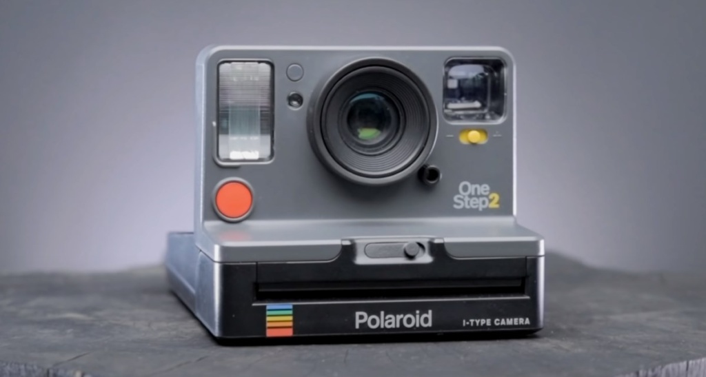 a grey Polaroid camera on a grey background 