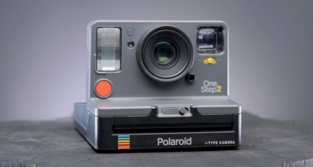 a grey Polaroid camera on a grey background